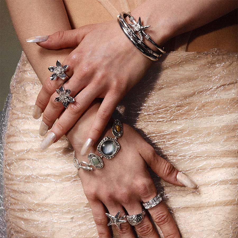 Coastal chic silver jewelry layering with Silver Starfish Bangle, rings, and chunky bracelets