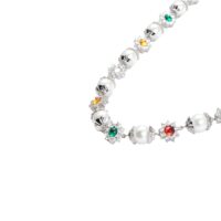 Macro close-up of glass pearl beads and daisy flower charms with CZ sparkle on silver-tone necklace