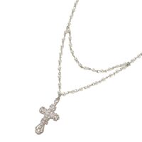 Everette Cross Necklace double‑layer pearl chain with silver CZ crystal cross pendant on white background