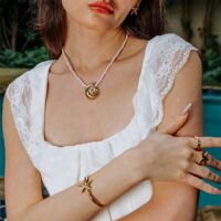 Gold Starfish Bangle styled with a gold shell pendant necklace and rings, coastal chic look
