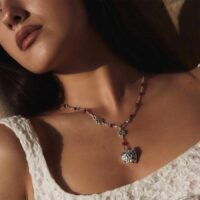Model wearing an antique silver lariat necklace with red carnelian beads and heart pendant (close-up)