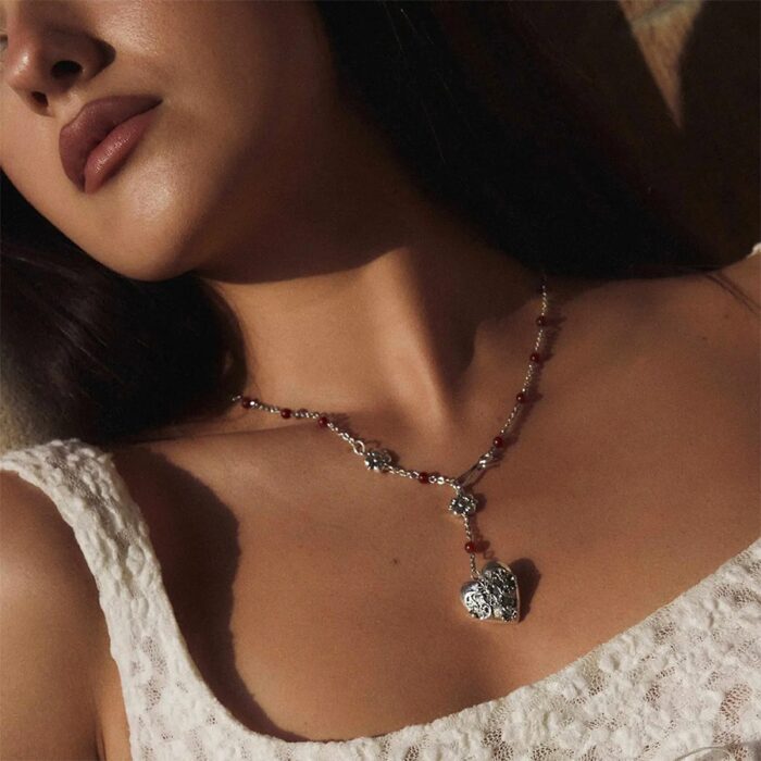 Model wearing an antique silver lariat necklace with red carnelian beads and heart pendant (close-up)
