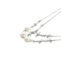 Silver layered charm necklace with baroque-style white pearls and crystal star charms on white
