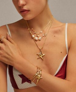 Layered gold starfish necklace stack with minimalist chains