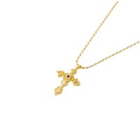 Close-up product photo of the Aphrodite Cross Necklace vintage filigree gold cross pendant with CZ sparkle and red center