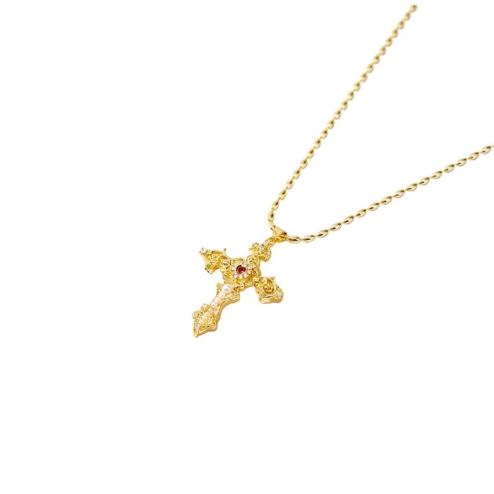 Close-up product photo of the Aphrodite Cross Necklace vintage filigree gold cross pendant with CZ sparkle and red center