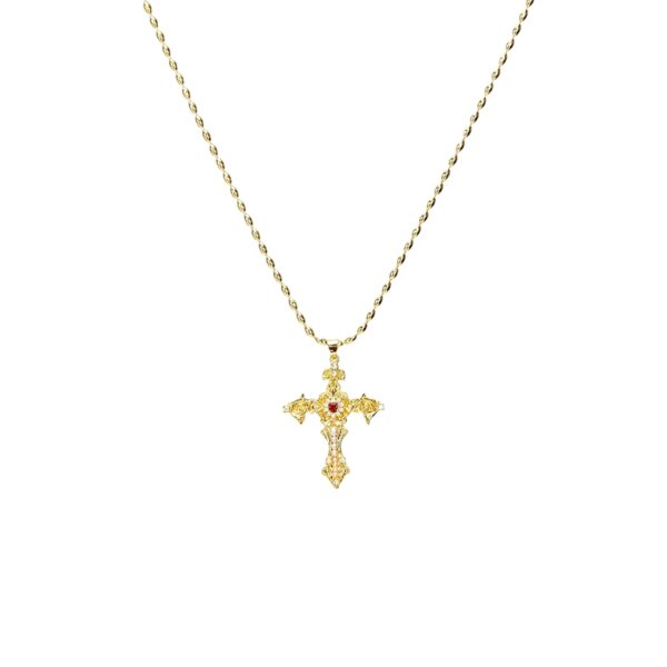Gold-toned vintage filigree Aphrodite cross necklace with CZ stones and a red center gemstone on a white background.