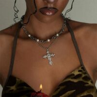 Close-up of Aphrodite Silver Cross Necklace ornate silver cross pendant layered under a pearl-accented chain, Gothic jewelry styling