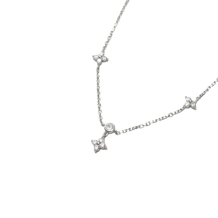 cz lucky clover necklace close-up of bezel-set round CZ with dangling floral clover charm on white