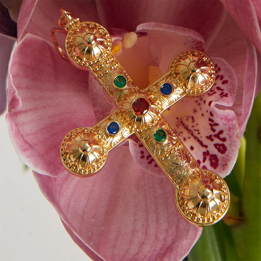Close-up of Daisy Molecule Chain filigree cross pendant with red blue and green stones