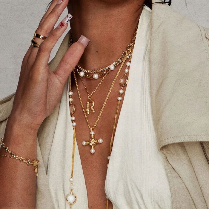 Florence Cross Golden Necklace worn with a pearl choker and initial necklace for a coquette-inspired layered look