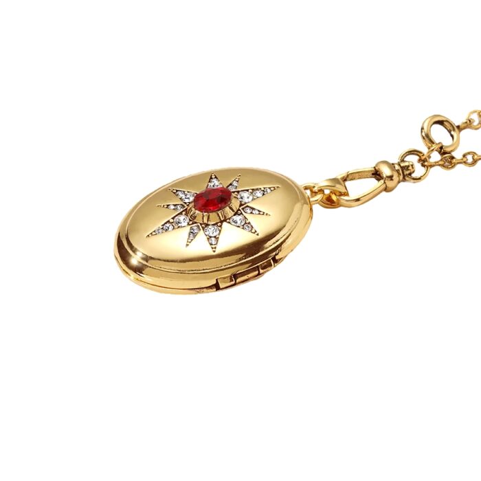 Gold oval locket pendant necklace with red gemstone center and crystal starburst detail