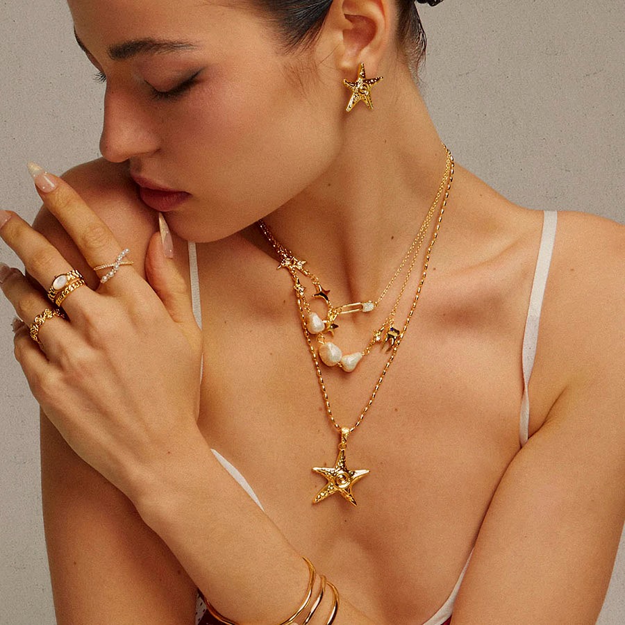 Mermaidcore coastal gold starfish necklace and earrings styled with pearl accent rings