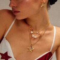 Mermaidcore coastal jewelry set layering with gold starfish necklace and matching stud earrings