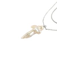 minimalist pearl cross necklace close-up—quiet luxury pearl necklace pendant for everyday layering