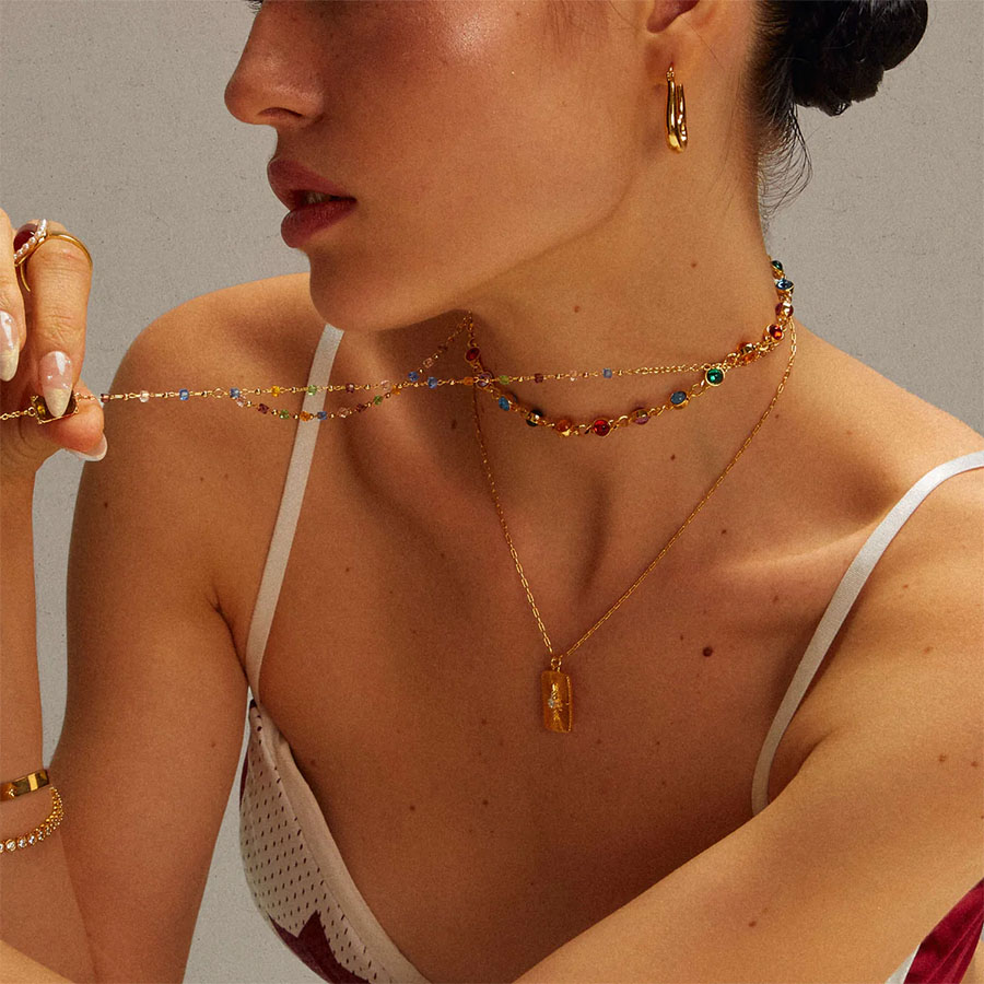 multicolor resin choker necklace close-up on neck with layered gold chains for everyday styling