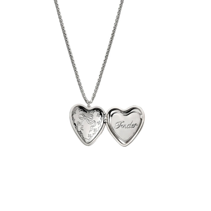 Openable heart locket necklace opened to show engraved bow inside and “Tender” script, silver tone on wheat chain