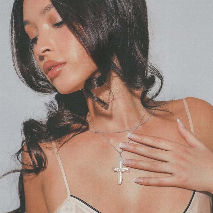 Pearl of Venus Necklace on model—baroque pearl cross necklace in a soft, quiet-luxury portrait