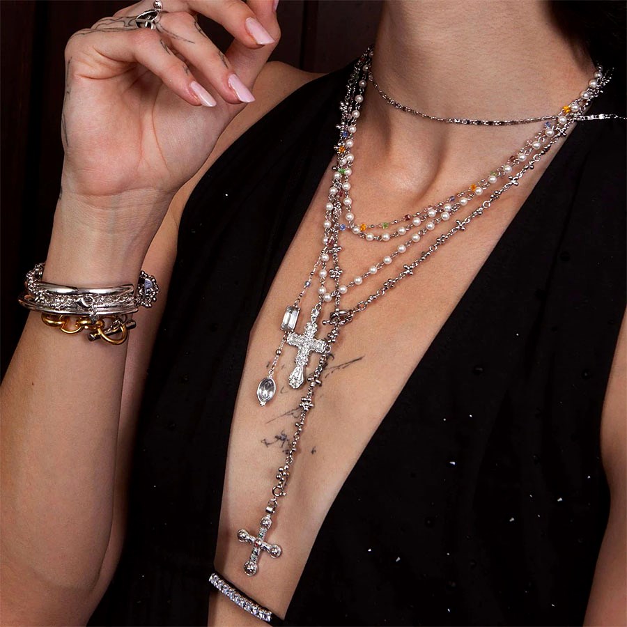 Silver Daisy Molecule Chain layered with pearls, beads, and cross necklaces in a stacked look