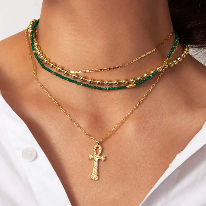 Layered look with a textured ankh necklace—a long egyptian ankh pendant necklace styled with mixed chains