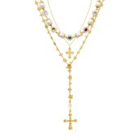 Urban Glam Golden Necklace Set gold layered cross necklace set with pearls and gemstone accents on white background