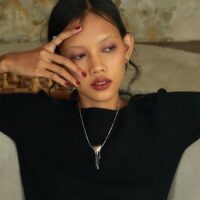 Woman wearing the Venom Drip Heart Necklace with a black top, silver dripping heart pendant visible, TikTok aesthetic jewelry