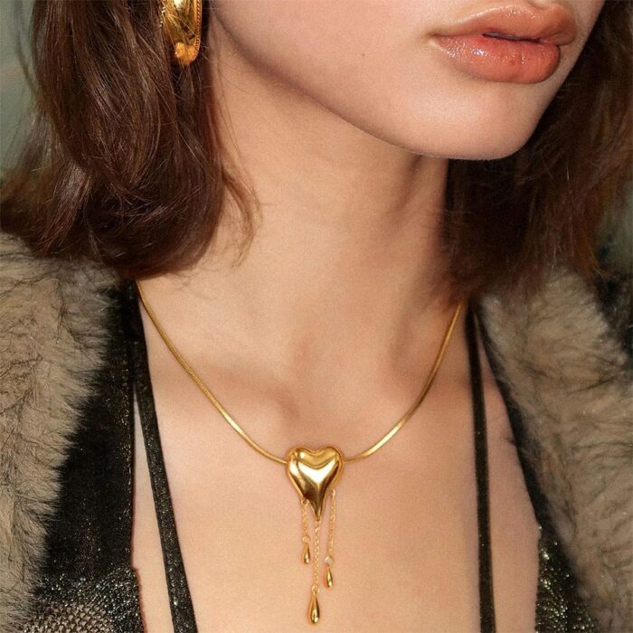 Model wearing Venom Golden Drip Heart Necklace with matching gold earring, Y2K gold jewelry styling